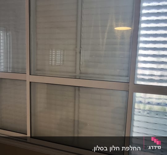 חלון הזזה גדול מזכוכית במסגרת אלומיניום בדירה